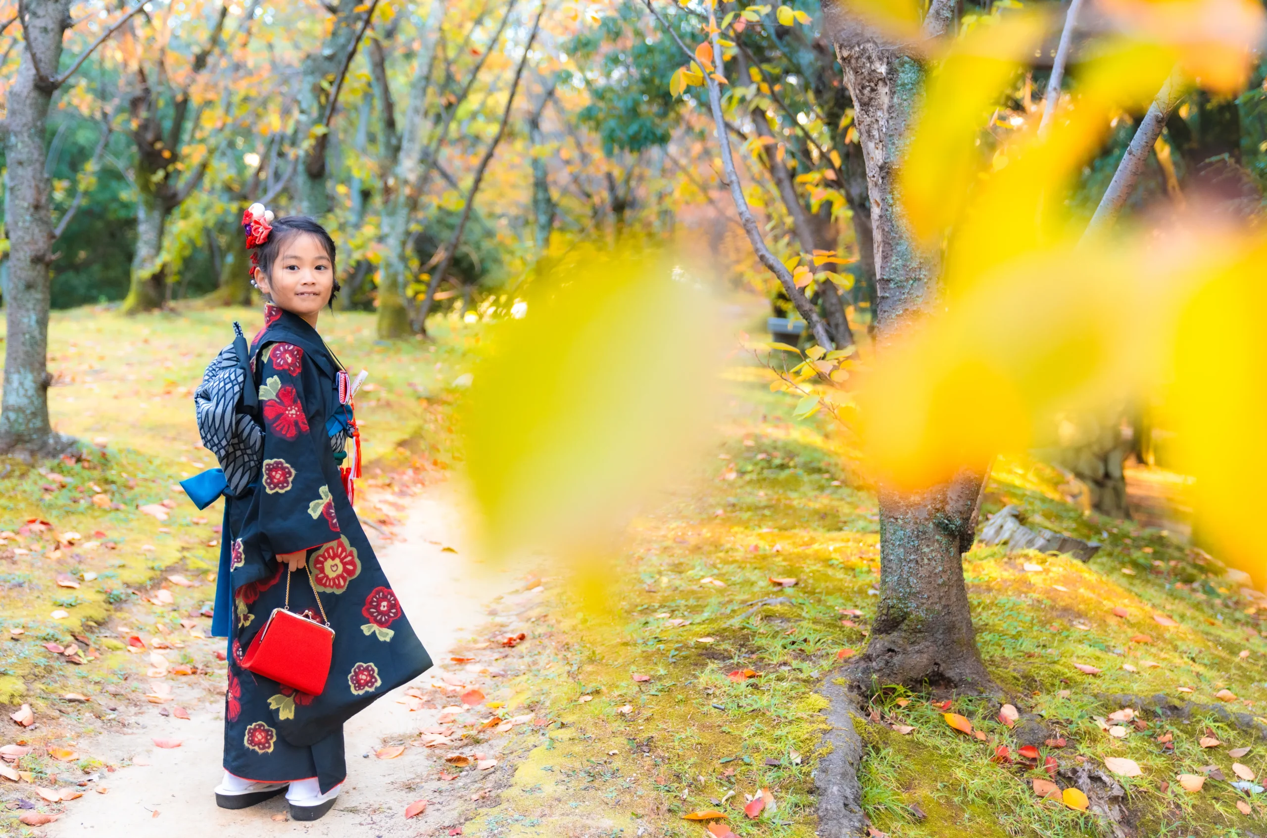 紅葉の後ろの女の子